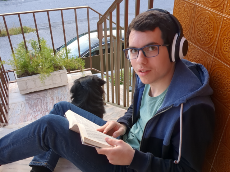 A white guy (me) reading a book, alongside his black Dog